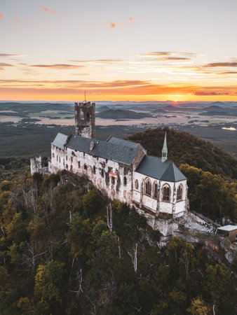 Bezdez Castle stands proudly atop a hill, bathed in the warm hues of sunset.の写真素材