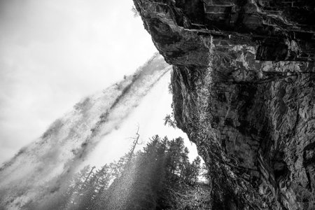 Johannes Waterfall cascades down rocky cliffs in Obertauern, surrounded by majestic alpine trees.