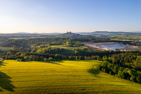 Visitors can enjoy the scenic views of Bohemian Paradise during summer. The landscape features Trosky Castle overlooking green fields and surrounding forests in Czechia.の写真素材