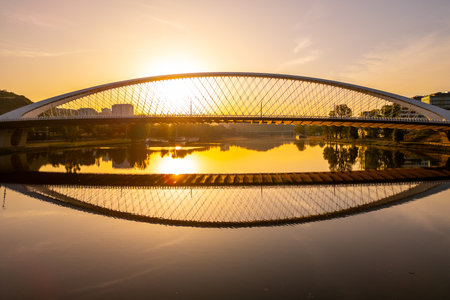 Troja Bridge stands over the Vltava River in Prague as the sun rises. The sky brightens with colors reflecting on the water below. A new day begins in this beautiful city.の写真素材