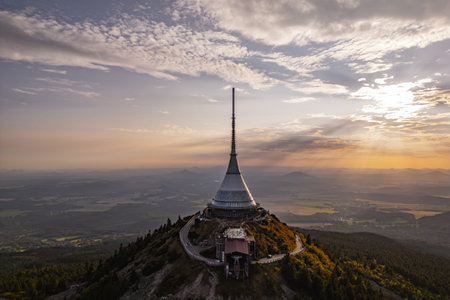 The Jested Mountain stands majestically on a hilltop in Liberec, showcasing its modern architecture against a backdrop of a beautiful sunset. The evening light enhances the scenic views.の写真素材