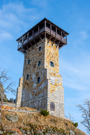 The lookout tower on Wysoki Kamien in the Jizera Mountains stands tall against a blue sky. Visitors...