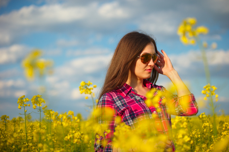 Girl in rape, yellow flowers, yellow sunlightの写真素材