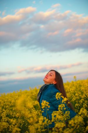 Girl in rape, yellow flowers, yellow sunlightの写真素材