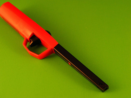 An extended safety lighter against a green background.