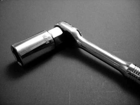 A stark black and white image of a socket wrench with a spark plug socket attached.の写真素材
