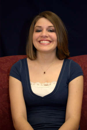 A pretty young brunette teenager on a sofa.の写真素材