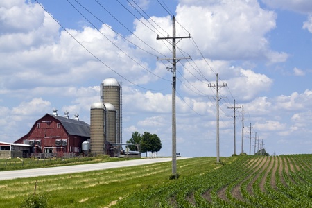 Red Barn and Crops by Road with Power Lineの写真素材