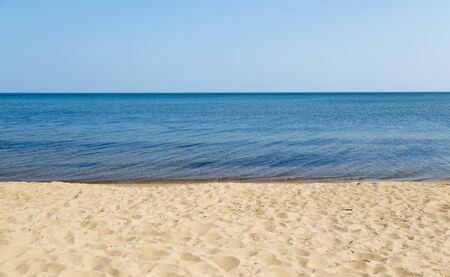 sandy beach with blue water and skyの写真素材