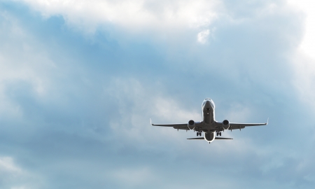 passenger airplane landing with dramatic dark cloudy skyの写真素材