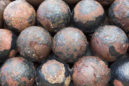 stack of old colonial rusty cannon ballsの写真素材