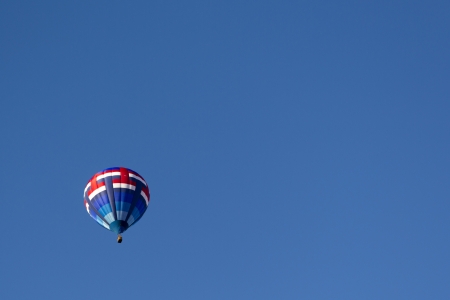 hot air balloon floating midair on the blue skyの写真素材
