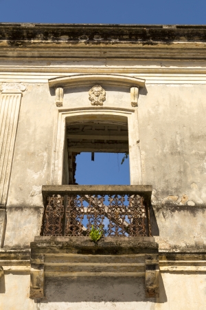 colonial balcony door in the ruins with blue sky showing throughの写真素材