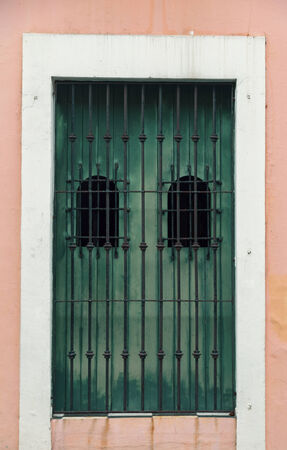 charming old barred Spanish door over pink wallの写真素材