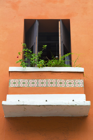 charming old Spanish balcony door on orange wall with balcony flowers in San Juan, Puerto Ricoの写真素材