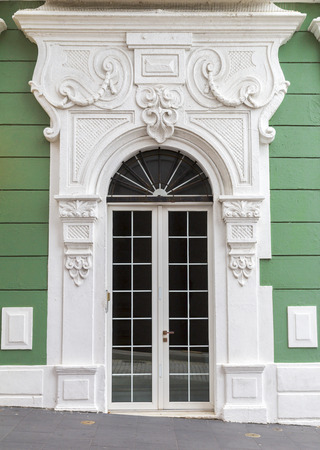 Renovated charming old Spanish door with decorative portal over green wall in San Juan, Puerto Ricoの写真素材