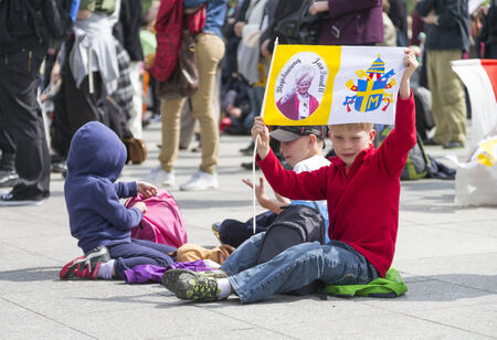 WARSAW, POLAND - APRIL 27: Young children with a papal flag during public transmission of canonization mass of Pope John Paul II at the Pilsudzki Square in Warsaw on April 27, 2014.のeditorial素材