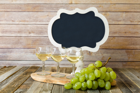 White wine flight with blank chalkboard sign and grapesの写真素材