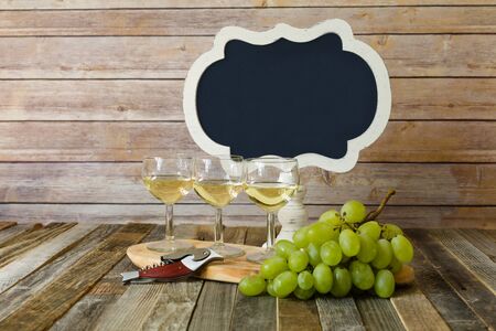 White wine flight with blank chalkboard sign and grapesの写真素材