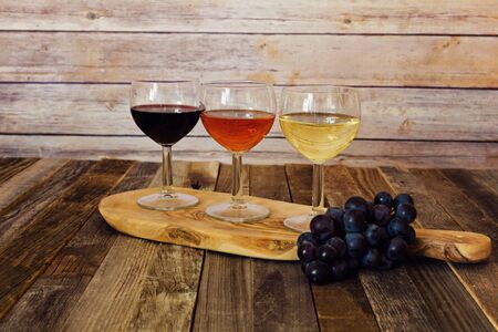 Wine flight on cutting board with grapesの写真素材