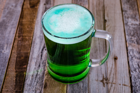Single mug of green beer on wooden background. Tabletop, side view.の写真素材