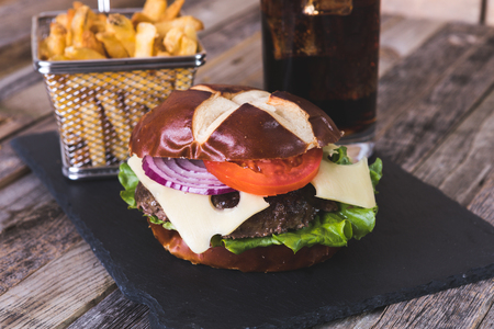 Gourmet cheeseburger with French fries and drink on wooden backgroundの写真素材