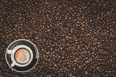Single small espresso coffee cup on roasted coffee beans backgroundの写真素材