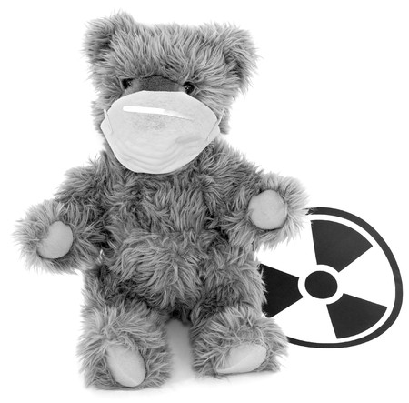 Toy brown baer in respirator and sign to radiationの写真素材