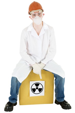 Man in doctor's smock and respirator sits on carton boxの写真素材