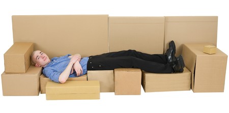 Man lying on sofa from carton boxの写真素材
