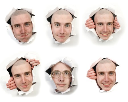 Six man's faces looking through holes in a paperの写真素材
