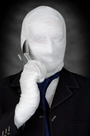 Mummy-businessman talking on telephone on the black backgroundの写真素材