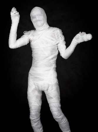 The man representing a mummy on black