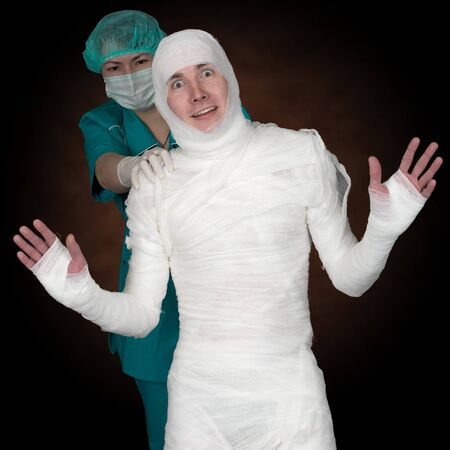 Man in bandage and nurse on black backgroundの写真素材