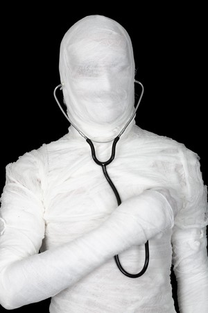 Man in costume mummy with stethoscope on blackの写真素材