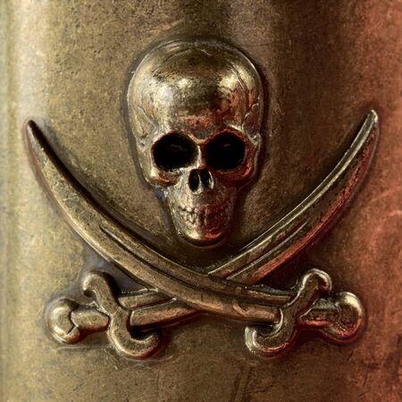 Skull and crossbones on the bronze metal backgroundの写真素材