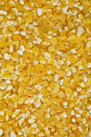 Yellow crushed maize cereals background close up