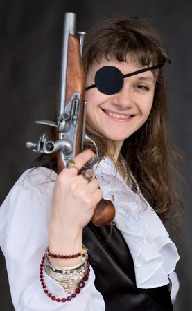 Girl - pirate with pistol in hand and eye patch on faceの写真素材