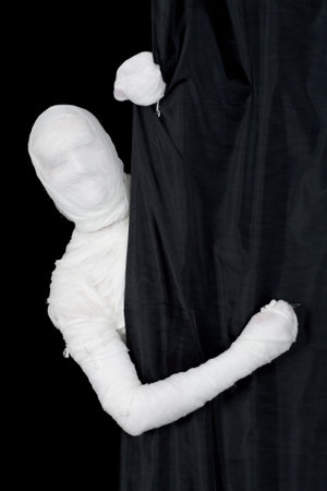 Man in bandage looking from behind of curtain
