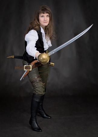 The girl - pirate with a sabre in hands on a black backgroundの写真素材