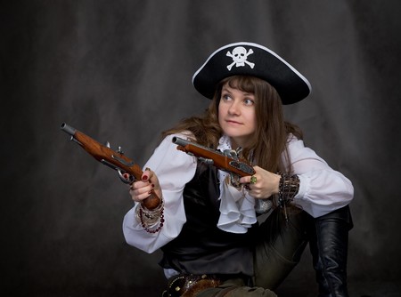 Girl - pirate on black with two pistols in handsの写真素材