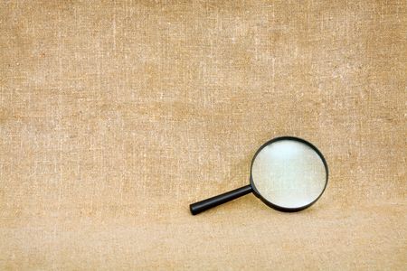 The magnifier lying against a brown sackingの写真素材