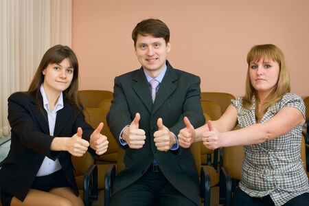 Team of cheerful businessmen show thumb upの写真素材