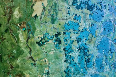 Old painted mangy wall of a building with cracks backgroundの写真素材