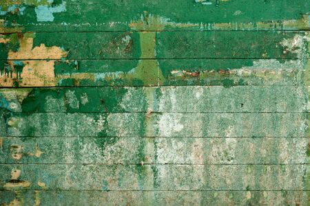 Green surface of the old, semidecayed wall covered with boardsの写真素材