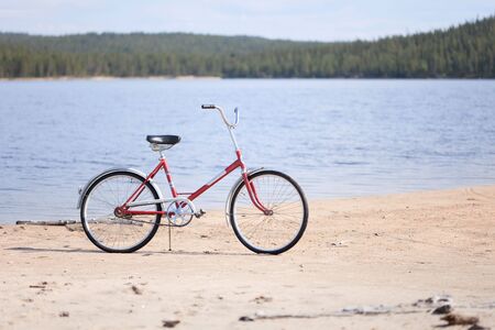 Old red bicycle photographed on a summer beachの写真素材