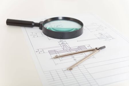 The drawings, magnifier and compasses on a white tableの写真素材