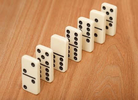A line from seven dominoes on a wooden surfaceの写真素材