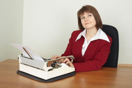 The young woman works on an ancient grandmother s typewriterの写真素材