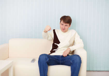 The people sits on a sofa with the remote controlの写真素材